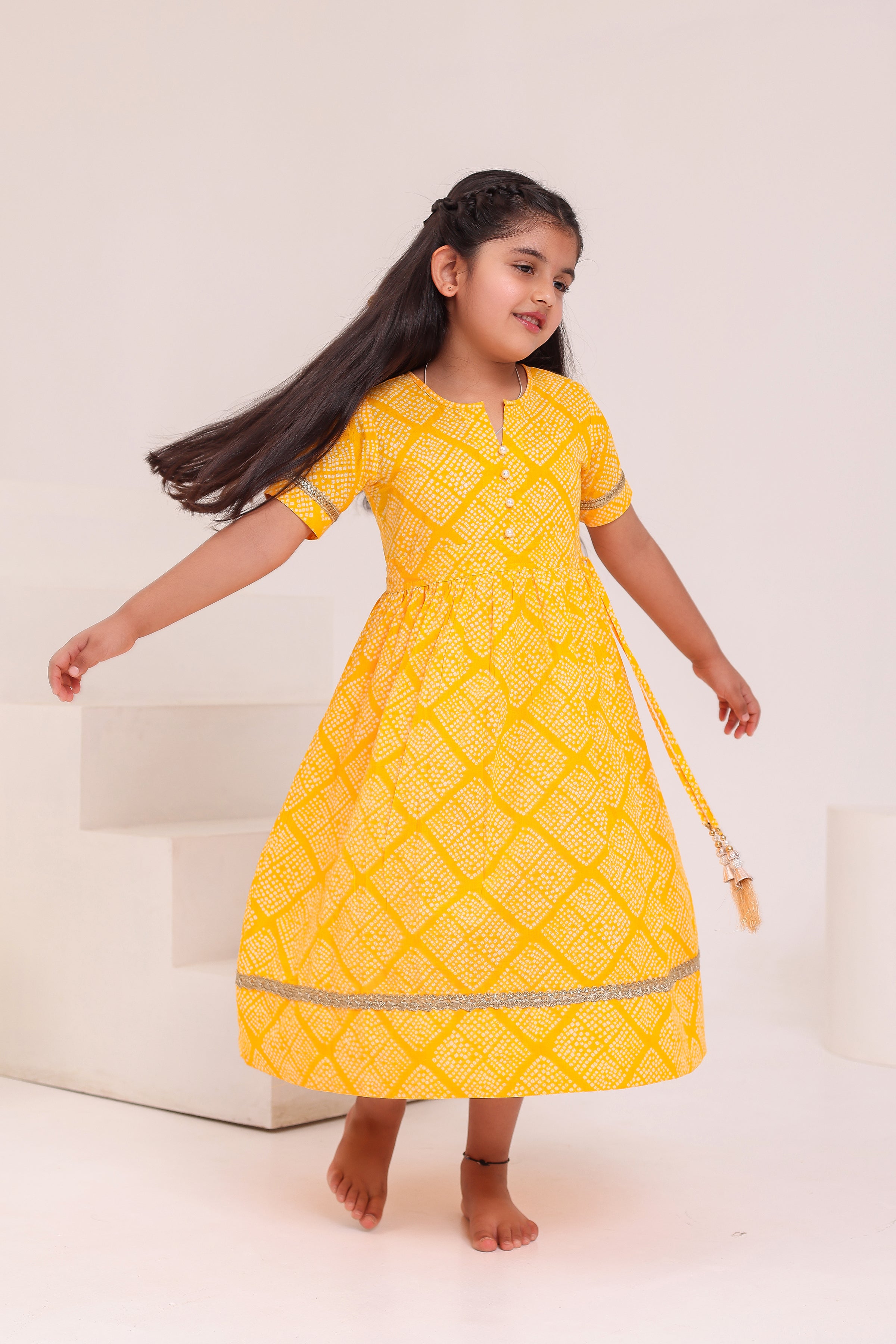 GIRLS YELLOW BANDHEJ PRINT ANKLE LENGTH ETHNIC GOTA DRESS WITH TASSELS