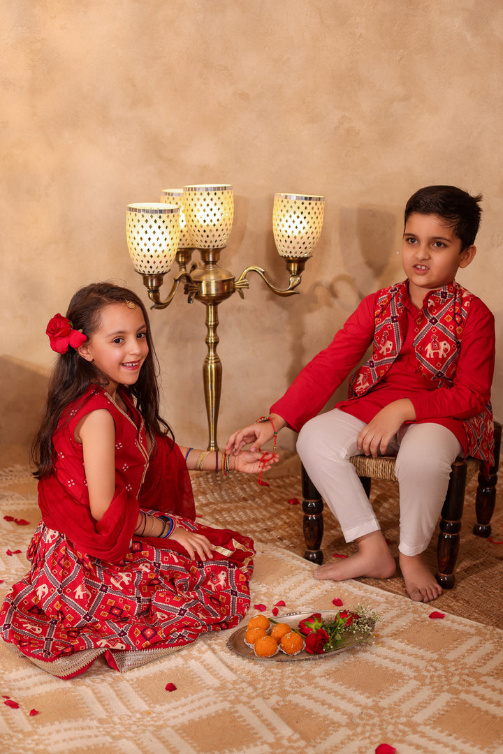 BOYS MAROON PATOLA PRINT JACKET WITH MAROON KURTA AND PAJAMA (SET OF 3) + GIRLS MAROON PATOLA PRINT LEHENGA WITH SLEEVELESS TOP AND DUPATTA (SET OF 3)
